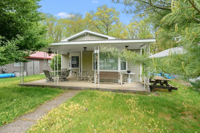 back of property featuring a yard and a patio