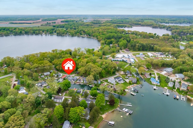 aerial view of property's location with a nearby body of water, a heavily wooded area, and nearby suburban area