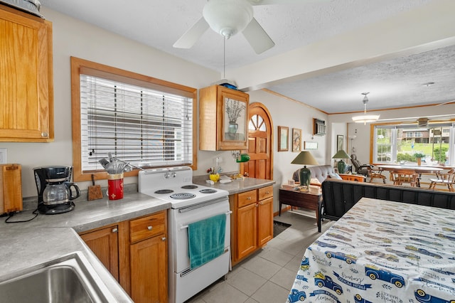 kitchen featuring white electric range oven, light tile patterned flooring, light countertops, and open floor plan