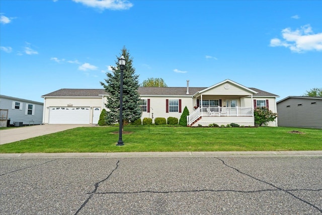 ranch-style home featuring covered porch, driveway, a front yard, a garage, and cooling unit