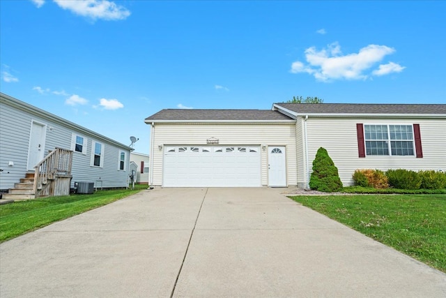 view of front facade with cooling unit, a garage, driveway, and a front yard
