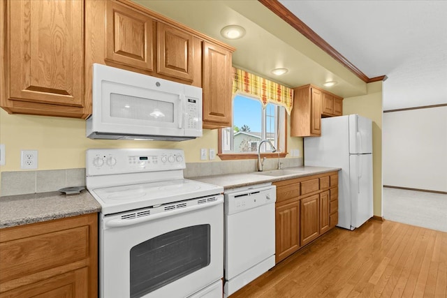 kitchen with white appliances, a sink, light wood-style floors, light countertops, and brown cabinets