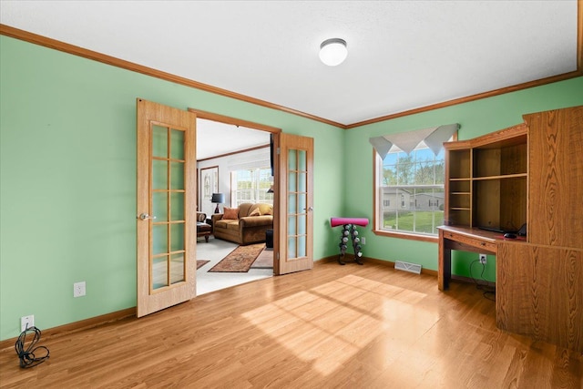 unfurnished office with french doors, wood finished floors, crown molding, baseboards, and plenty of natural light
