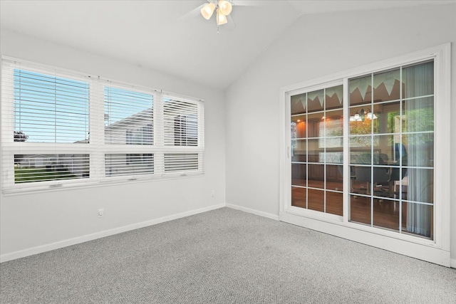 carpeted empty room featuring baseboards, ceiling fan, and vaulted ceiling