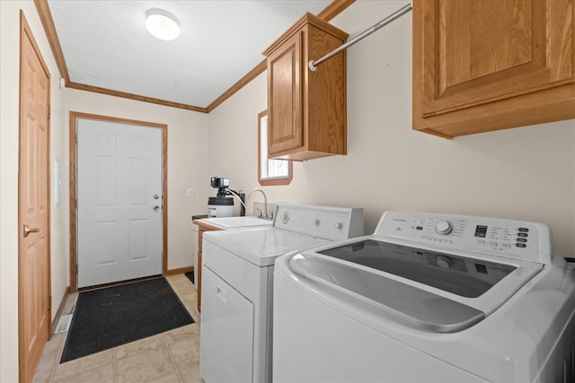 laundry area with washing machine and clothes dryer, cabinet space, crown molding, and baseboards