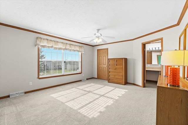 unfurnished bedroom featuring light colored carpet, baseboards, ornamental molding, a ceiling fan, and a closet