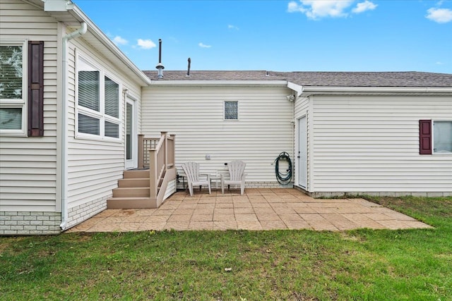 rear view of property with a patio, a yard, and a shingled roof