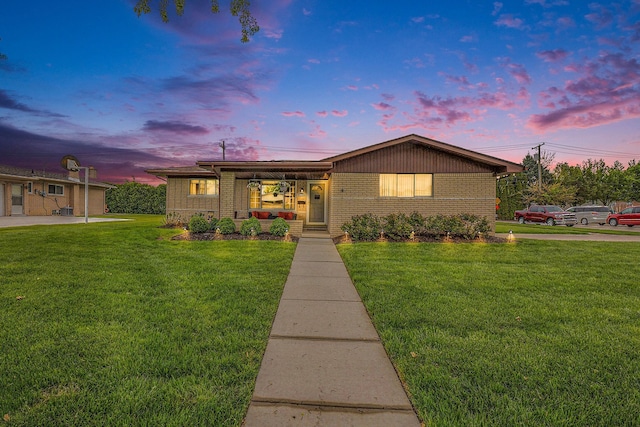 ranch-style home featuring a front yard and brick siding
