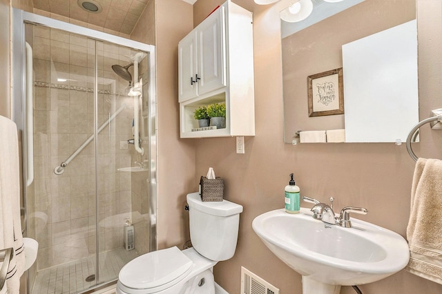 full bathroom featuring a sink, a shower stall, and toilet
