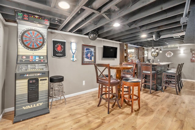 indoor bar with baseboards, wood finished floors, and stacked washer / drying machine