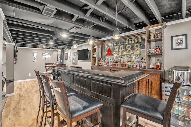 indoor bar featuring wood finished floors and baseboards
