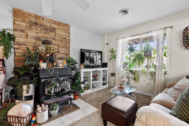tiled living area featuring a ceiling fan and carpet