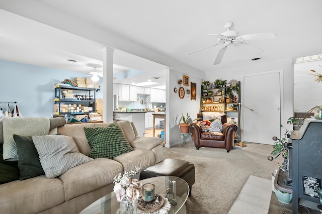 living room with ceiling fan, light colored carpet, and decorative columns