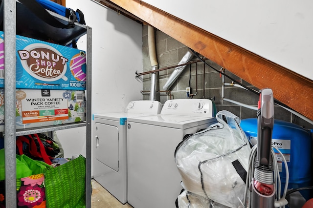 washroom with washer and clothes dryer and concrete block wall