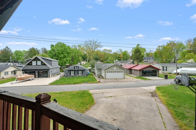 view of green lawn with a residential view and a garage