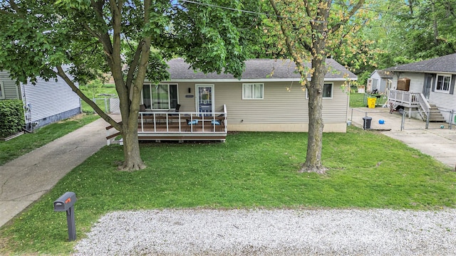 44080 Davis, Utica, MI 48317 - view of front of home with a front lawn, a wooden deck, roof with shingles, an outbuilding, and a storage shed