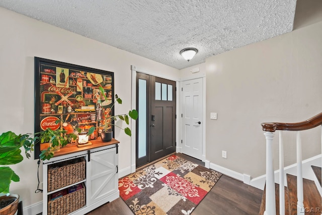 608 Budlong St, Adrian, MI 49221 - entrance foyer featuring dark wood-style flooring, stairway, a textured ceiling, and baseboards