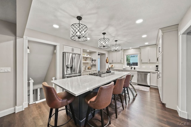 608 Budlong St, Adrian, MI 49221 - kitchen with stainless steel appliances, a kitchen island, light stone counters, a breakfast bar area, and recessed lighting