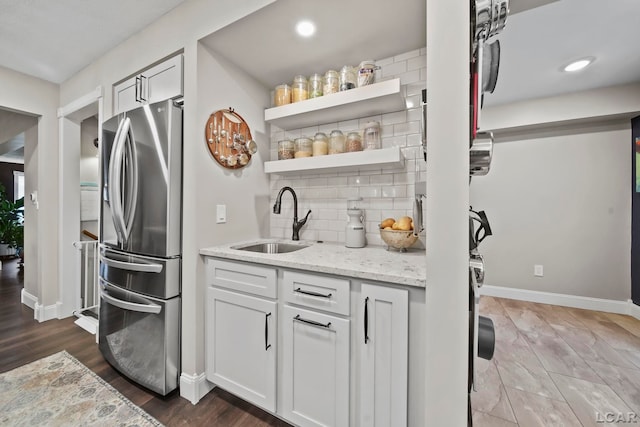 608 Budlong St, Adrian, MI 49221 - kitchen featuring freestanding refrigerator, a sink, baseboards, backsplash, and light stone countertops