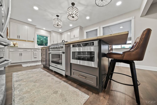 608 Budlong St, Adrian, MI 49221 - kitchen featuring white cabinetry, tasteful backsplash, appliances with stainless steel finishes, light countertops, and recessed lighting