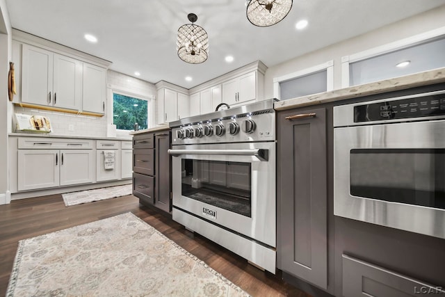 608 Budlong St, Adrian, MI 49221 - kitchen with stainless steel stove, dark wood-style floors, backsplash, white cabinets, and recessed lighting