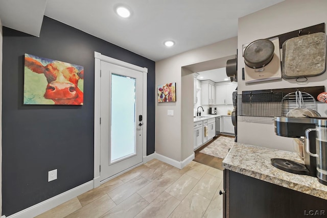 608 Budlong St, Adrian, MI 49221 - kitchen with a sink, light countertops, baseboards, recessed lighting, and white cabinetry