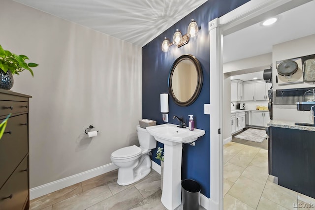 608 Budlong St, Adrian, MI 49221 - bathroom featuring baseboards, toilet, and a sink
