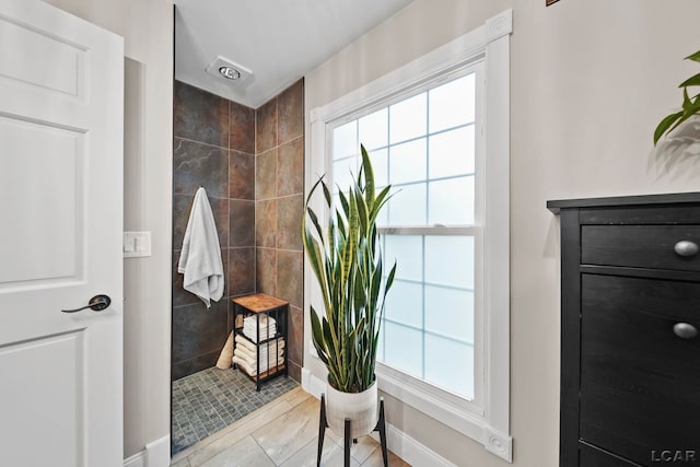 608 Budlong St, Adrian, MI 49221 - full bath with tiled shower, plenty of natural light, and baseboards