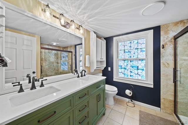 608 Budlong St, Adrian, MI 49221 - bathroom featuring tile patterned floors, a stall shower, baseboards, toilet, and double vanity