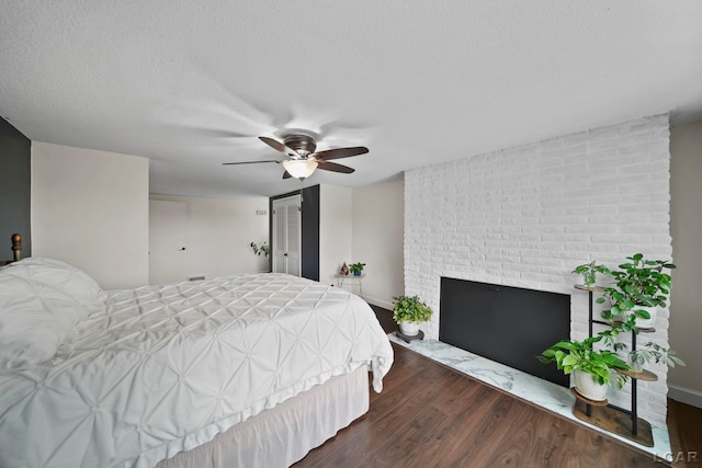 608 Budlong St, Adrian, MI 49221 - bedroom with a brick fireplace, wood finished floors, a textured ceiling, a ceiling fan, and a closet