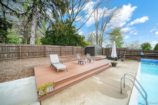 608 Budlong St, Adrian, MI 49221 - view of swimming pool featuring a storage unit, a fenced backyard, an outbuilding, and a patio