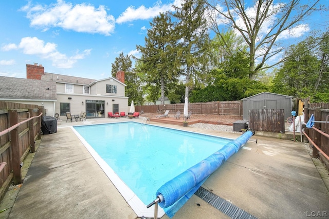 608 Budlong St, Adrian, MI 49221 - view of pool with a fenced backyard, a storage unit, a patio area, and an outbuilding