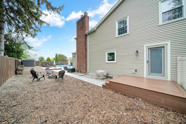 608 Budlong St, Adrian, MI 49221 - fenced backyard with a deck, a fire pit, and central AC