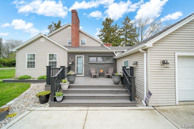 608 Budlong St, Adrian, MI 49221 - back of house featuring a deck, a chimney, an attached garage, and a shingled roof