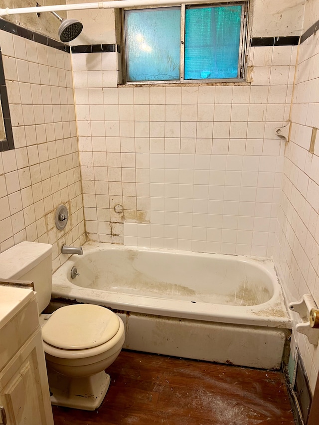 bathroom with toilet, hardwood / wood-style flooring,  shower combination, and vanity