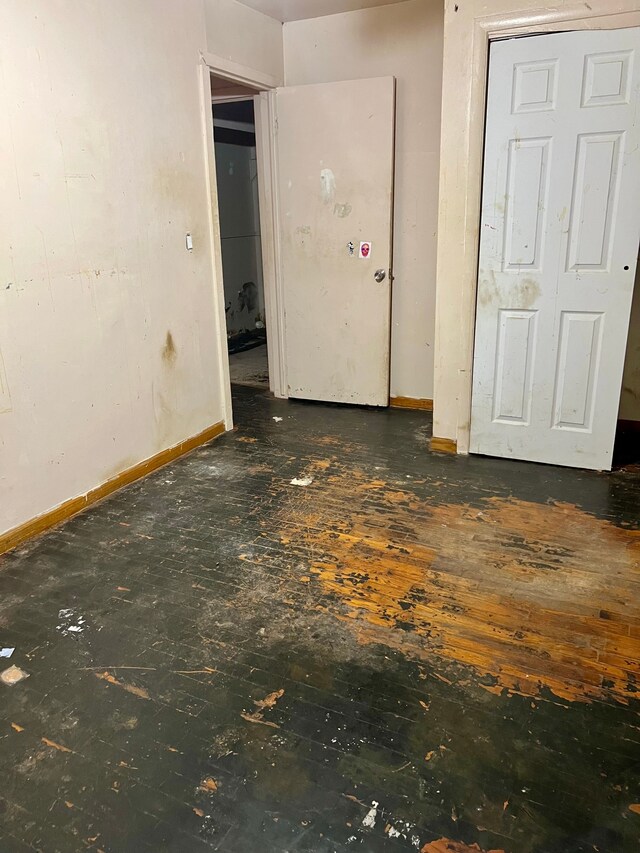unfurnished bedroom featuring baseboards and wood-type flooring