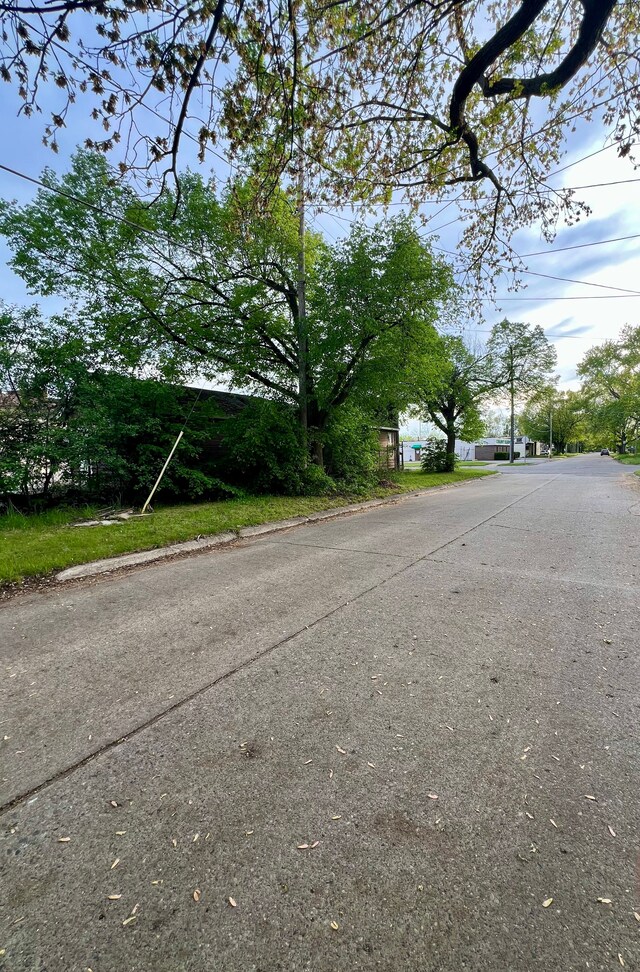view of asphalt street with curbs