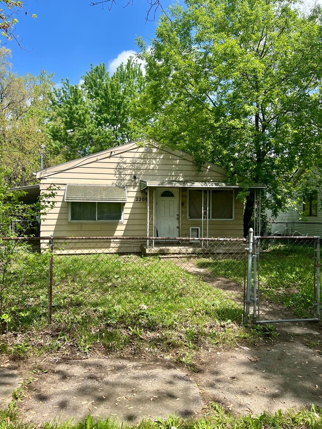 bungalow-style home with a fenced front yard and a gate