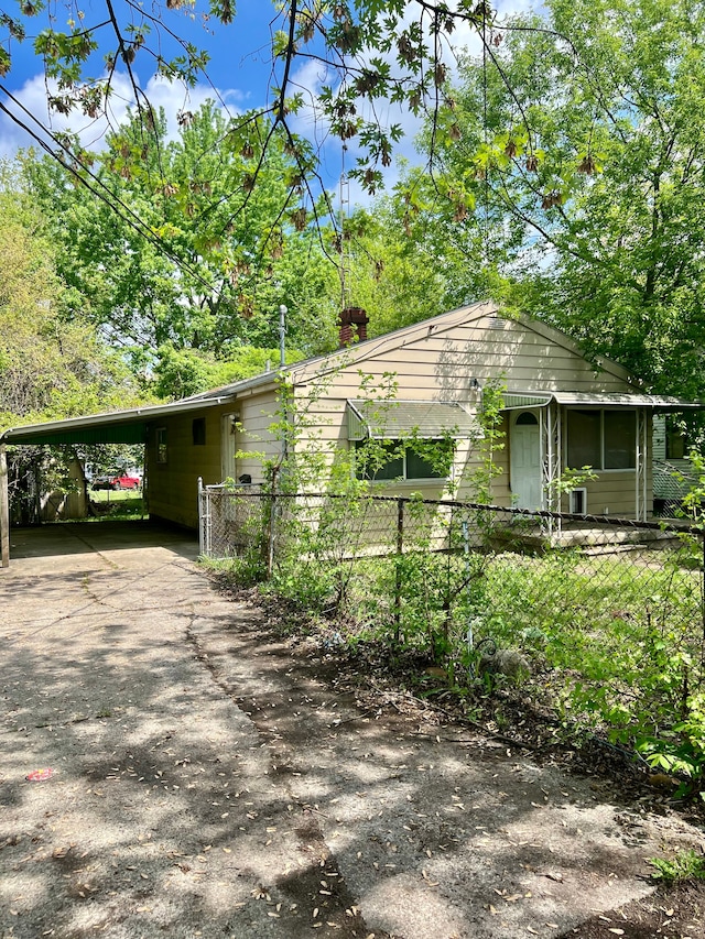 2209 Kansas Ave, Flint, MI 48506 - view of property exterior with a carport, driveway, and fence