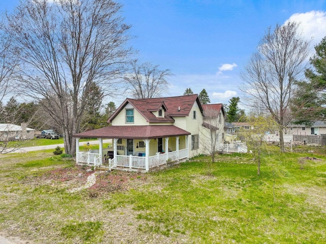 512 Kalkaska Rd NW, Kalkaska, MI 49646 - rear view of property featuring covered porch, a lawn, and roof with shingles