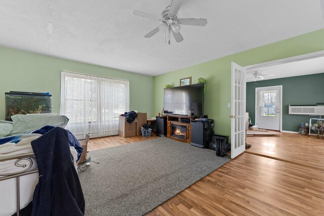 512 Kalkaska Rd NW, Kalkaska, MI 49646 - living room with a ceiling fan, french doors, wood finished floors, and a fireplace