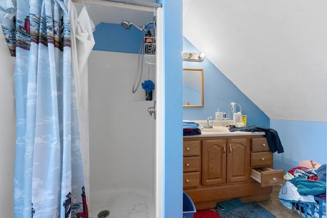 512 Kalkaska Rd NW, Kalkaska, MI 49646 - bathroom featuring vaulted ceiling, a stall shower, vanity, tile patterned floors, and a textured ceiling