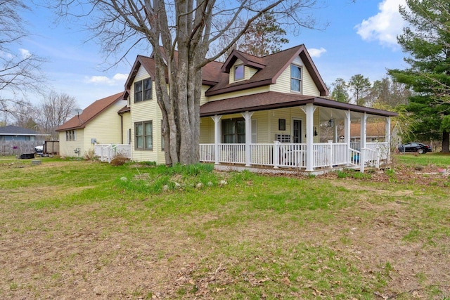 512 Kalkaska Rd NW, Kalkaska, MI 49646 - view of front facade featuring covered porch, a front yard, and a shingled roof