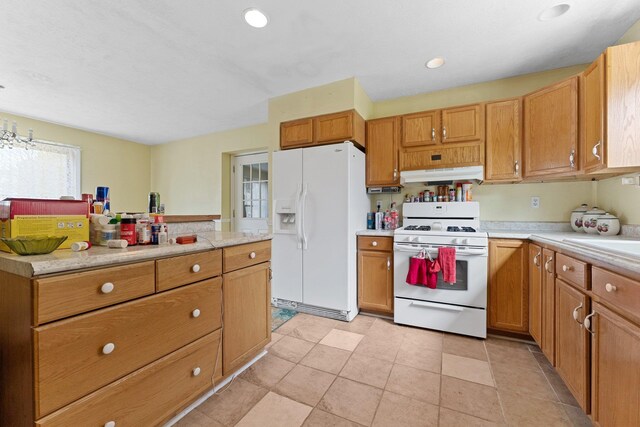 512 Kalkaska Rd NW, Kalkaska, MI 49646 - kitchen featuring white appliances, under cabinet range hood, and light countertops