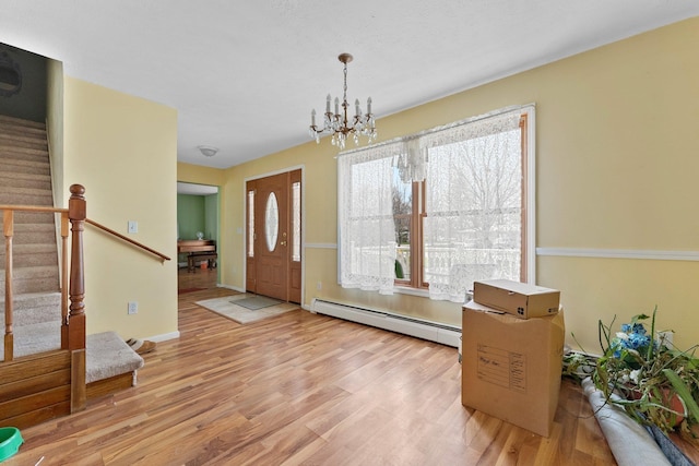 512 Kalkaska Rd NW, Kalkaska, MI 49646 - entryway featuring a baseboard radiator, stairs, wood finished floors, and a chandelier