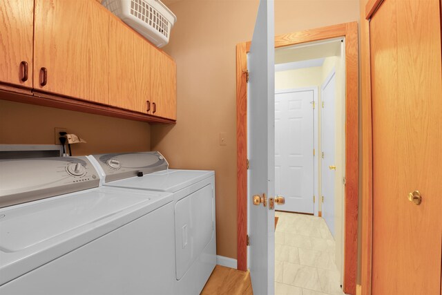7017 Loud Dr, Oscoda, MI 48750 - laundry area featuring independent washer and dryer and cabinet space