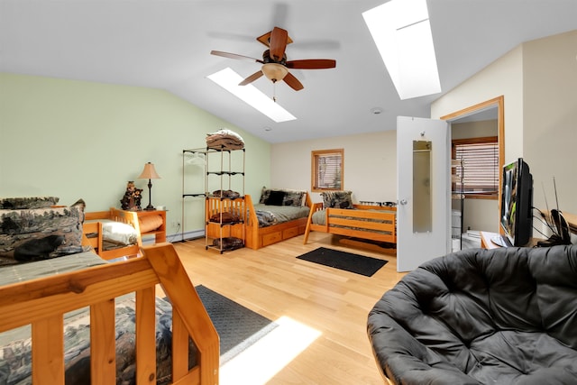 7017 Loud Dr, Oscoda, MI 48750 - bedroom with a skylight, vaulted ceiling, wood finished floors, multiple windows, and a ceiling fan