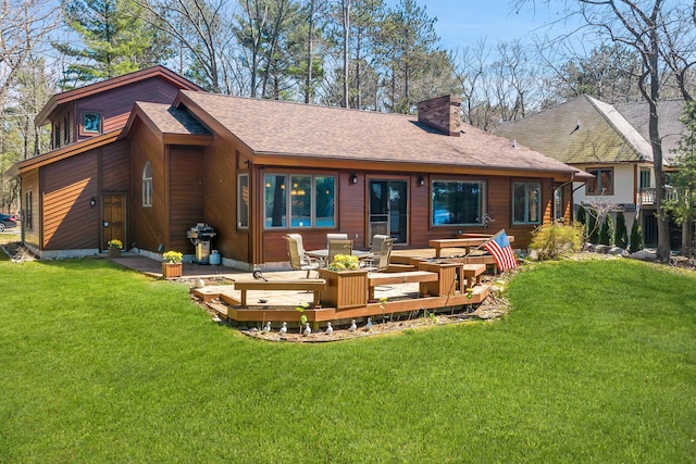 7017 Loud Dr, Oscoda, MI 48750 - rear view of property with a wooden deck, a chimney, a lawn, and a shingled roof