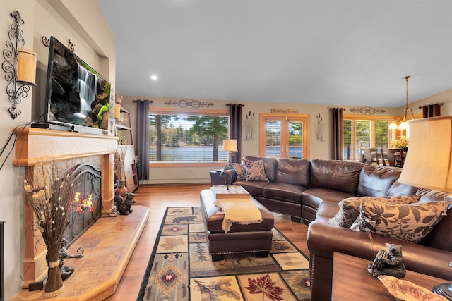 7017 Loud Dr, Oscoda, MI 48750 - living room with wood finished floors, plenty of natural light, a baseboard radiator, a fireplace, and recessed lighting