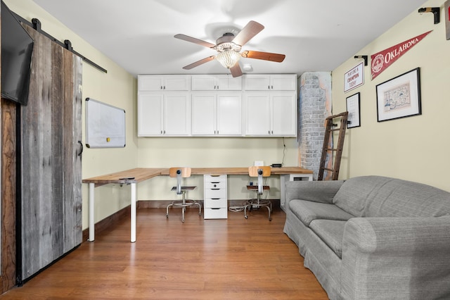 3694 Kerlikowske Rd, Coloma, MI 49038 - home office featuring wood finished floors, ceiling fan, built in desk, and a barn door